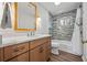 Bathroom features wood cabinetry, shower over bath, modern fixtures and stunning backsplash at 1416 Vernon Ridge Close, Dunwoody, GA 30338