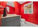 Bright red bathroom with stylish round mirror, dark vanity, and black-and-white tile floor at 1416 Vernon Ridge Close, Dunwoody, GA 30338
