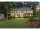 Classic two-story home featuring a lush green lawn and mature trees enhancing its curb appeal at 1416 Vernon Ridge Close, Dunwoody, GA 30338