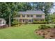 Charming two-story home with a well-manicured lawn, mature trees, and lush landscaping at 1416 Vernon Ridge Close, Dunwoody, GA 30338