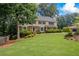 Lovely two-story home features a lush green lawn, mature trees, and manicured landscaping at 1416 Vernon Ridge Close, Dunwoody, GA 30338