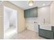 A well-lit laundry room with tile floors, storage, and a utility sink at 1416 Vernon Ridge Close, Dunwoody, GA 30338