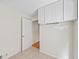 An open room featuring white walls, tile floors, and overhead storage cabinets at 1416 Vernon Ridge Close, Dunwoody, GA 30338