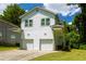 Charming two-story home with white siding, dual garage doors, and a well-manicured lawn at 2027 Lois Pl, Atlanta, GA 30318