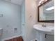 Bathroom features pedestal sink, framed mirror, wood floors, and a separate shower at 110 Silverthorne Dr, Douglasville, GA 30134