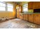 Dated kitchen with yellow walls, two windows, and wooden cabinets with dark hardware at 969 Byron Sw Dr, Atlanta, GA 30310
