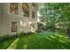 Landscaped backyard featuring an expansive lawn, manicured garden beds, and a charming cottage-style home exterior at 10650 Centennial Dr, Alpharetta, GA 30022