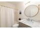 Updated bathroom with a round mirror, marble countertop vanity, and a shower with a curtain at 10650 Centennial Dr, Alpharetta, GA 30022