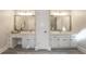 Bright bathroom featuring double sinks with white cabinets and marble countertops at 10650 Centennial Dr, Alpharetta, GA 30022