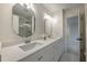 Bright bathroom featuring double sinks with white cabinets and quartz countertops at 10650 Centennial Dr, Alpharetta, GA 30022