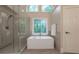 Bright bathroom featuring a glass shower, soaking tub and stained glass window at 10650 Centennial Dr, Alpharetta, GA 30022
