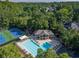 Aerial view of a pristine community pool and tennis courts surrounded by lush greenery at 10650 Centennial Dr, Alpharetta, GA 30022