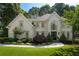 Inviting home featuring a lush green lawn, mature landscaping, and an elegant facade with a welcoming entrance at 10650 Centennial Dr, Alpharetta, GA 30022