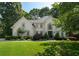 Inviting home featuring a lush green lawn, mature landscaping, and an elegant facade with a welcoming entrance at 10650 Centennial Dr, Alpharetta, GA 30022