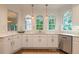 Bright kitchen boasts marble countertops, stainless steel appliances, and three arched windows allowing ample natural light at 10650 Centennial Dr, Alpharetta, GA 30022