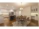 Open concept kitchen featuring modern island, stainless appliances, and breakfast nook with elegant light fixture at 10650 Centennial Dr, Alpharetta, GA 30022