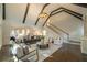 Bright living room featuring vaulted ceilings, dark beams, open floor plan, and easy access to staircase at 10650 Centennial Dr, Alpharetta, GA 30022