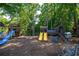 Community playground with slides, swings, and climbing structures nestled among tall trees at 10650 Centennial Dr, Alpharetta, GA 30022