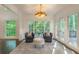 Bright sunroom featuring neutral colors, plush seating, transom windows, and a view of the outdoors at 10650 Centennial Dr, Alpharetta, GA 30022