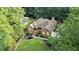Aerial view of a brick home with mature trees, manicured lawn, and ample driveway space at 2525 Fairview Dr, Cumming, GA 30041