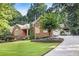 Brick home boasts a manicured lawn, mature trees, and an extended driveway at 2525 Fairview Dr, Cumming, GA 30041