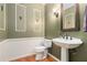 Stylish powder room with pedestal sink and decorative mirror at 2525 Fairview Dr, Cumming, GA 30041