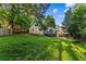 Backyard view of home featuring a well-maintained lawn, lush trees, and deck with ramp for outdoor relaxation at 6719 Sunset Valley Cir, Rex, GA 30273