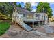 A quaint home featuring a wooden deck and ramp surrounded by lush greenery and a concrete driveway at 6719 Sunset Valley Cir, Rex, GA 30273