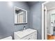 Bathroom featuring a white vanity and a square mirror against a gray wall at 6719 Sunset Valley Cir, Rex, GA 30273