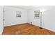Well-lit bedroom with hardwood floors, two windows, and white painted walls at 6719 Sunset Valley Cir, Rex, GA 30273