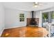 Bright living room with hardwood floors, a ceiling fan, a window, glass doors, and a wood burning fireplace at 6719 Sunset Valley Cir, Rex, GA 30273