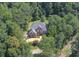 An aerial view reveals a grand two-story brick home nestled among towering trees, showcasing its serene setting at 1350 Whitley Rd, Dacula, GA 30019