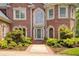 Close up of a charming brick home with manicured landscaping and a decorative entry door at 1350 Whitley Rd, Dacula, GA 30019