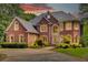 A red brick two-story home with a large window, complemented by manicured landscaping, exuding curb appeal at 1350 Whitley Rd, Dacula, GA 30019