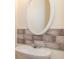 Half bathroom featuring gray tile detail and a white oval mirror at 2284 Nicole Dr, Hampton, GA 30228