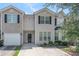 Attractive townhome featuring light siding, black shutters, and a one-car garage on a sunny day at 2284 Nicole Dr, Hampton, GA 30228