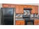 Kitchen featuring wood cabinets, gray countertops, and black appliances at 2284 Nicole Dr, Hampton, GA 30228