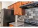 Kitchen featuring wood cabinets, gray countertops, and black appliances at 2284 Nicole Dr, Hampton, GA 30228