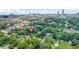 Aerial view showcasing property nestled among mature trees with the city skyline in the distance at 935 Pelham Nw St, Atlanta, GA 30318