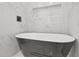 Bright bathroom featuring white and gray tiling with a modern soaking tub at 935 Pelham Nw St, Atlanta, GA 30318
