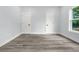 Bedroom with gray vinyl flooring, one window with backyard views, and two closets at 935 Pelham Nw St, Atlanta, GA 30318