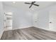 A bedroom with gray vinyl flooring, ceiling fan, ensuite bathroom, and neutral paint at 935 Pelham Nw St, Atlanta, GA 30318