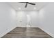 Spacious bedroom features wood-look flooring, ceiling fan, and ensuite bathroom with a peek of a tile shower at 935 Pelham Nw St, Atlanta, GA 30318