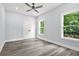 Bedroom featuring gray vinyl flooring, ceiling fan, two windows, and a closet at 935 Pelham Nw St, Atlanta, GA 30318