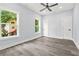 Bedroom with gray vinyl flooring, two windows with tree views, and two closets at 935 Pelham Nw St, Atlanta, GA 30318