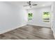 Bedroom with sleek gray vinyl flooring, two windows overlooking the backyard, and neutral paint at 935 Pelham Nw St, Atlanta, GA 30318