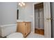 Bright bathroom with tile floor featuring a toilet, sink vanity, and open doorway at 1775 Whooping Creek Rd, Carrollton, GA 30116