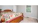 A bedroom featuring natural light and a wooden bedframe with a colorful quilt at 1775 Whooping Creek Rd, Carrollton, GA 30116