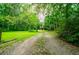 Long gravel driveway leading to a charming home in a wooded setting at 1775 Whooping Creek Rd, Carrollton, GA 30116