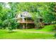 Beautiful home exterior with large deck and lush green lawn, surrounded by mature trees at 1775 Whooping Creek Rd, Carrollton, GA 30116